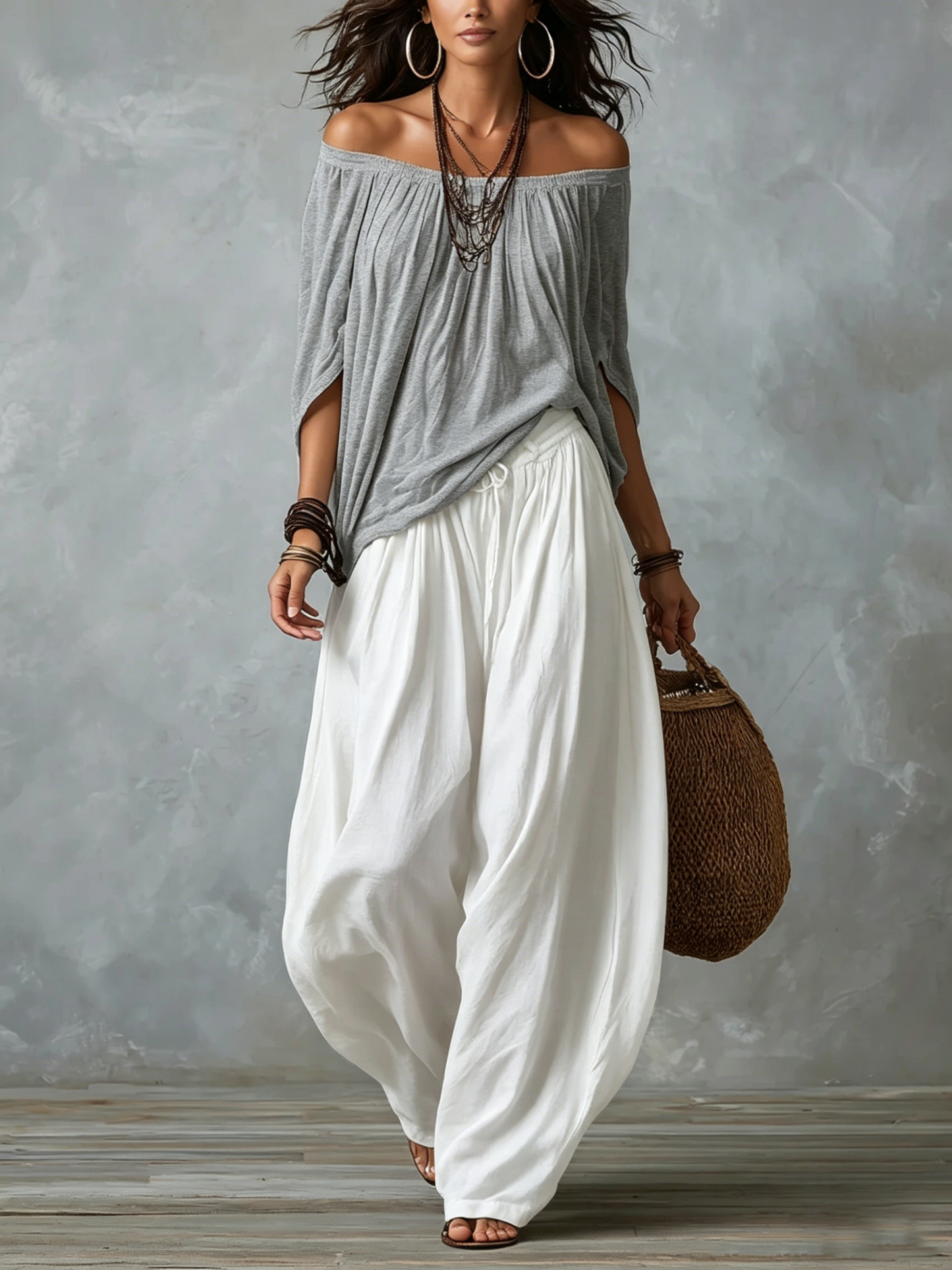 Top grigio con spalle scoperte e completo con pantaloni bianchi ampi a lanterna