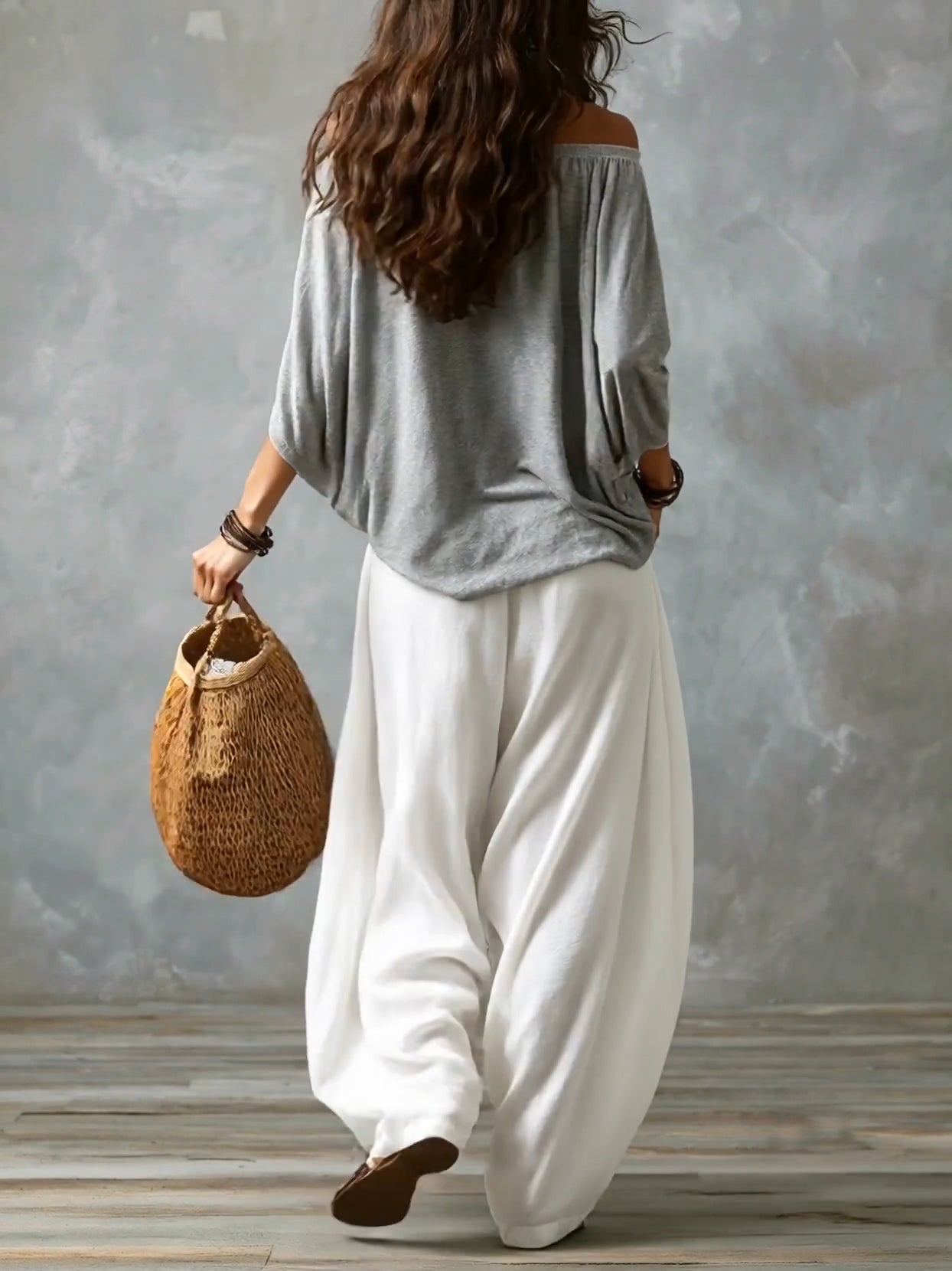 Top grigio con spalle scoperte e completo con pantaloni bianchi ampi a lanterna